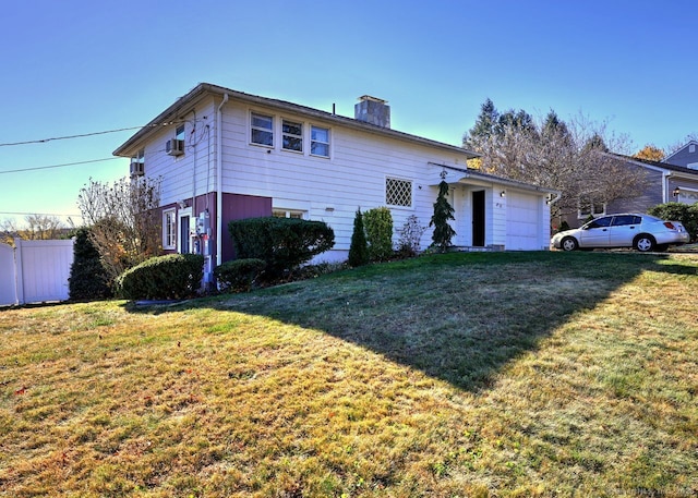 view of property featuring a front lawn and a garage