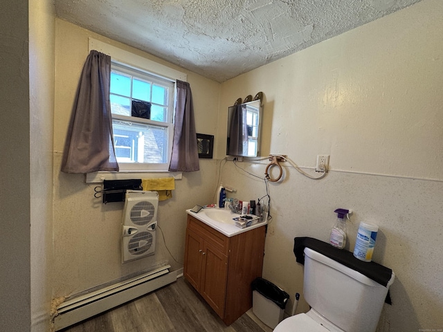 bathroom with hardwood / wood-style floors, vanity, a textured ceiling, a baseboard radiator, and toilet