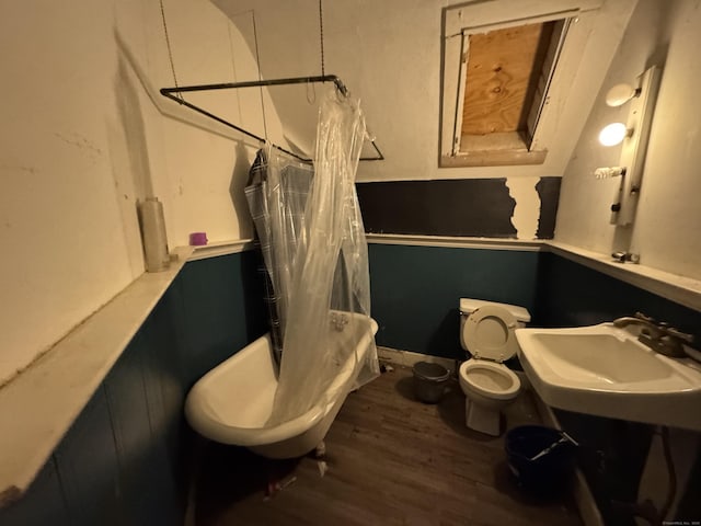 full bathroom featuring sink, hardwood / wood-style flooring, toilet, and shower / bath combo with shower curtain