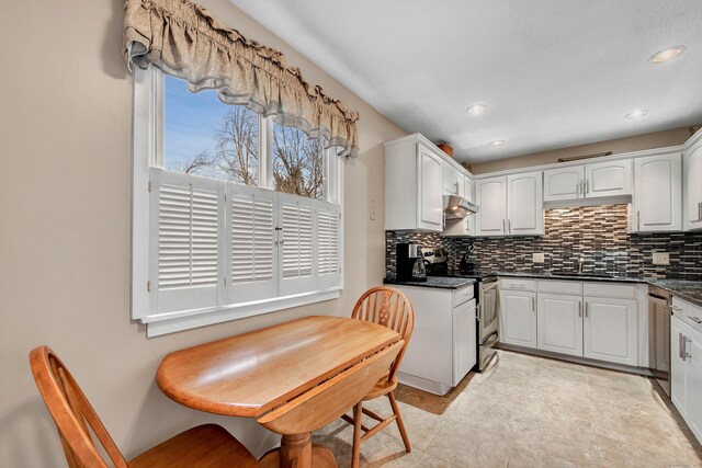 kitchen featuring appliances with stainless steel finishes, white cabinetry, sink, backsplash, and light tile patterned floors