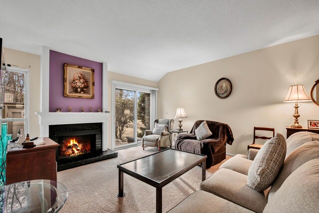 carpeted living room with vaulted ceiling, a fireplace, and a textured ceiling