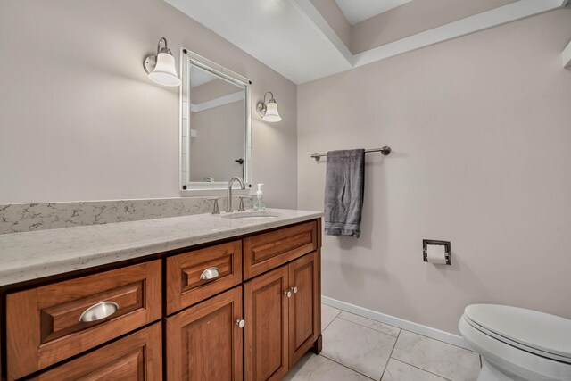 bathroom featuring toilet, vanity, and tile patterned flooring