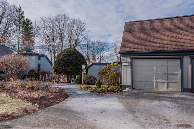 view of side of home featuring a garage and an outdoor structure