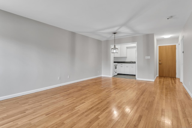 unfurnished living room with light wood-type flooring and sink