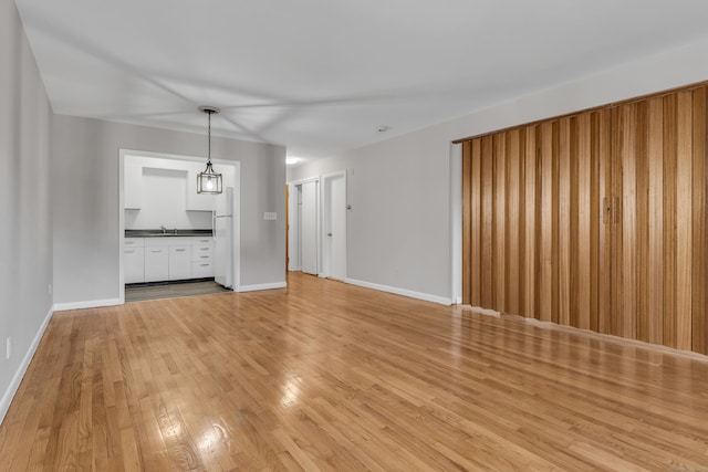 unfurnished living room with light hardwood / wood-style floors and sink