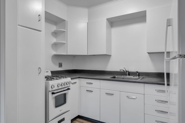 kitchen with white range with gas stovetop, white cabinets, and sink