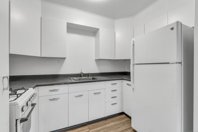 kitchen with white appliances, white cabinetry, wood-type flooring, sink, and ornamental molding