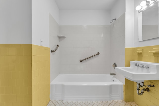 bathroom with sink, tile walls, tiled shower / bath combo, and tile patterned flooring