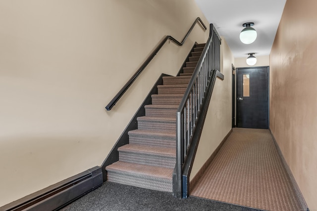 stairs featuring carpet floors and baseboard heating