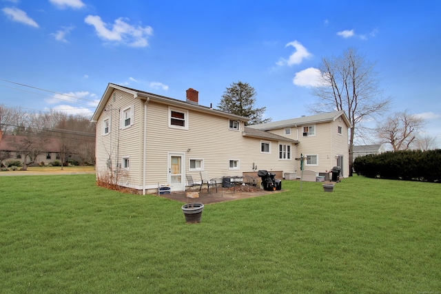 rear view of house with a yard and a patio