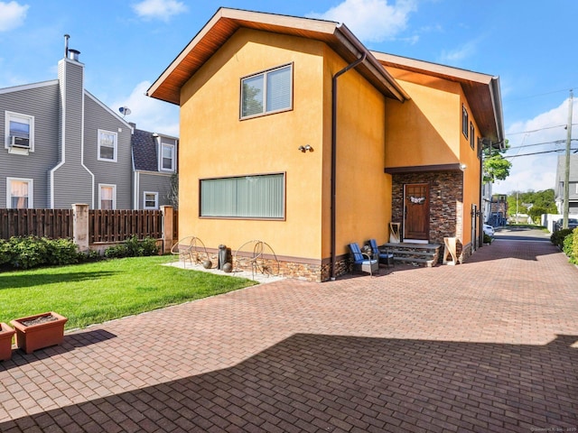 rear view of property with a lawn and a patio area