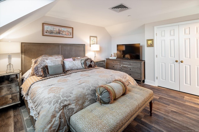 bedroom featuring a closet, lofted ceiling, and dark hardwood / wood-style flooring