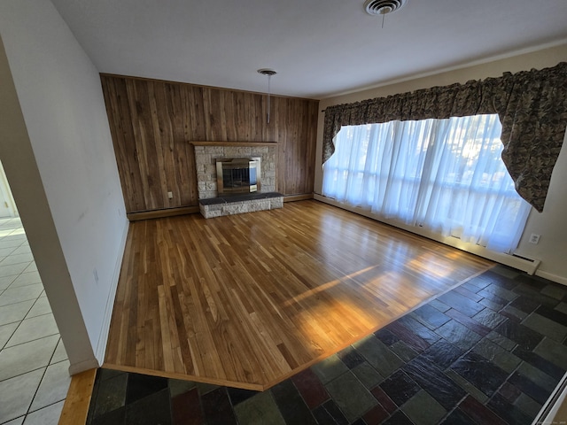 unfurnished living room featuring a stone fireplace