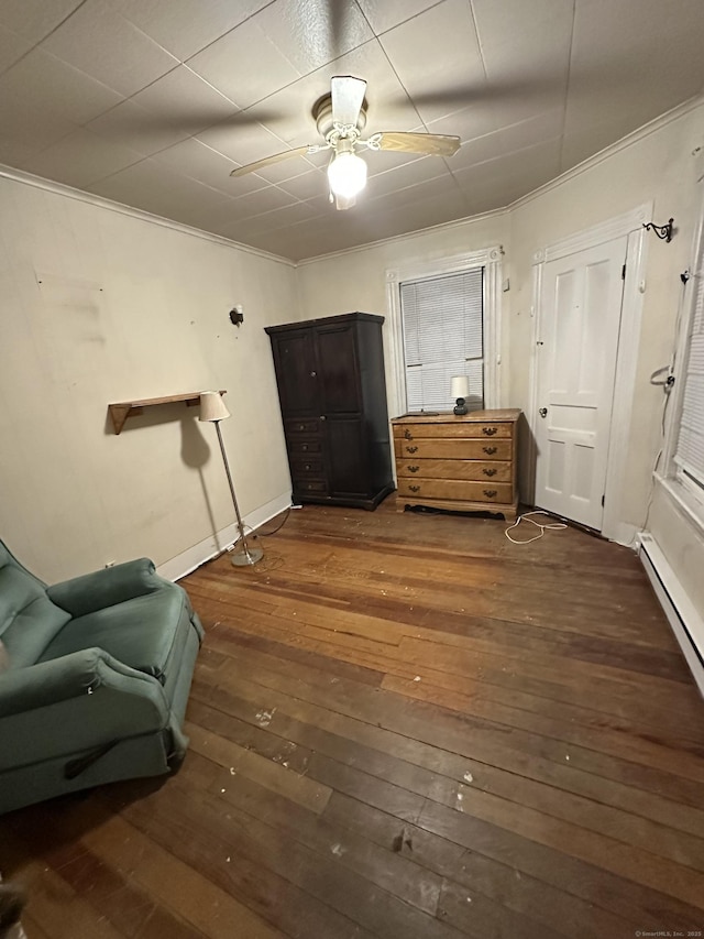 sitting room with ceiling fan, dark wood-type flooring, a baseboard radiator, and ornamental molding