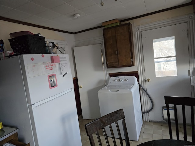 washroom with cabinets, washer / dryer, and ornamental molding