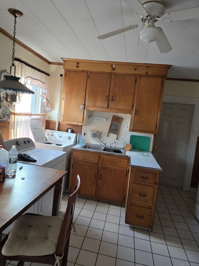 kitchen featuring ornamental molding, ceiling fan, sink, separate washer and dryer, and decorative light fixtures