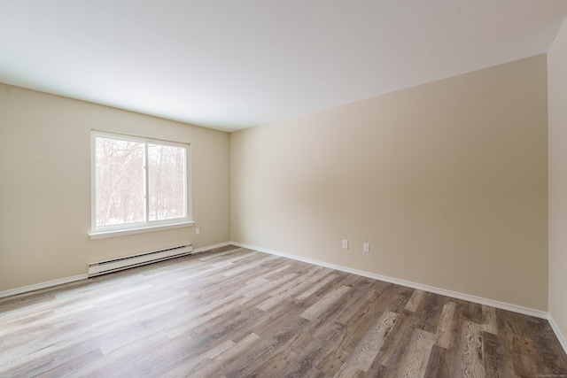 empty room with a baseboard heating unit and light wood-type flooring