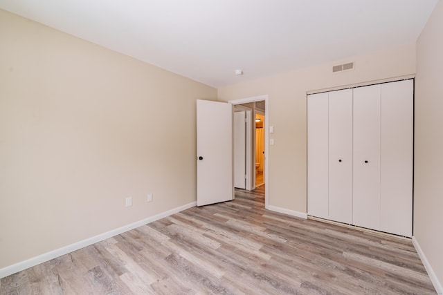 unfurnished bedroom with a closet and light wood-type flooring