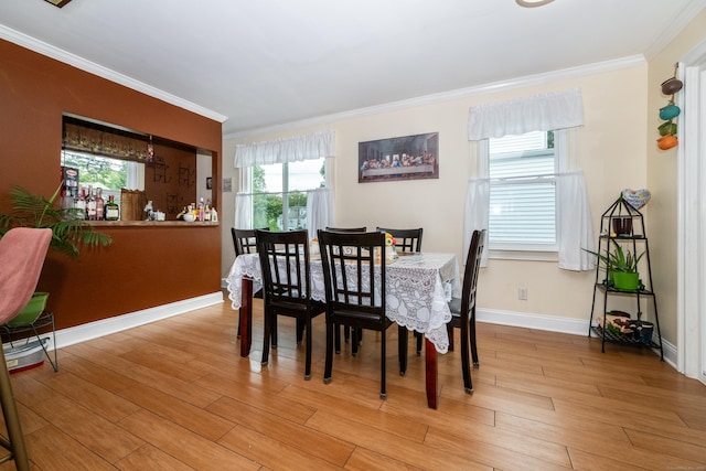 dining space with crown molding and light hardwood / wood-style flooring