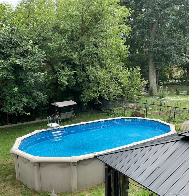 view of swimming pool featuring a yard