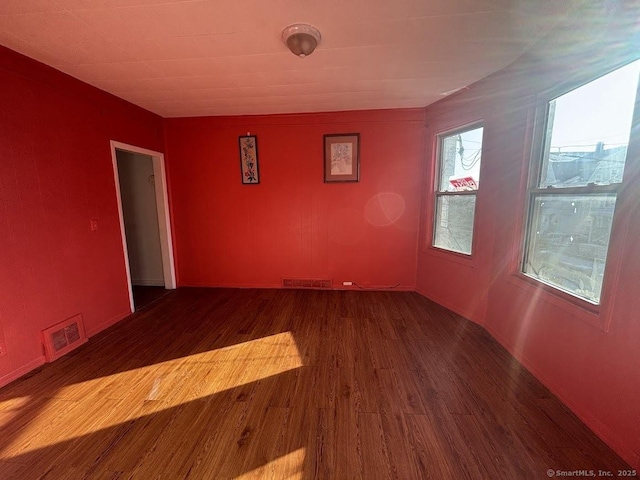 unfurnished room with dark wood-type flooring