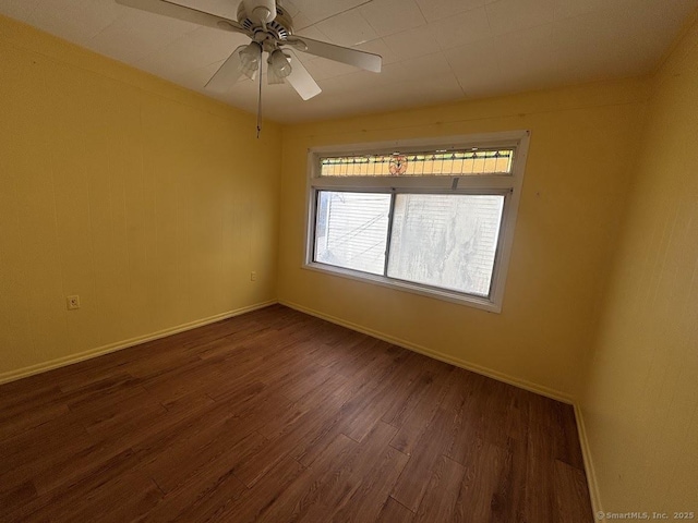 spare room with dark wood-type flooring and ceiling fan