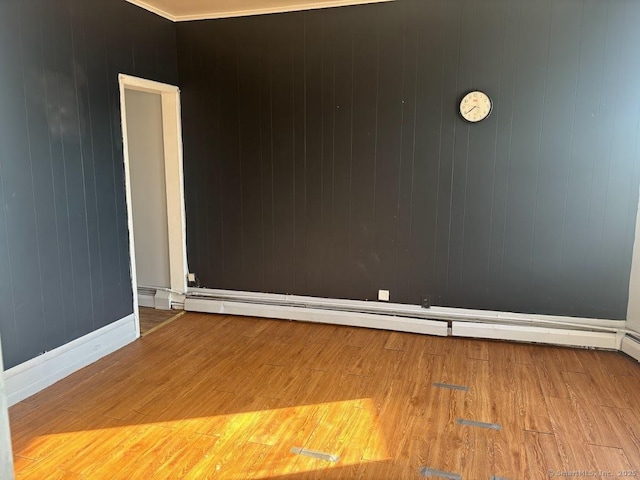 spare room with hardwood / wood-style flooring and a baseboard radiator