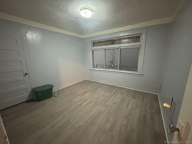 spare room featuring a textured ceiling and hardwood / wood-style flooring