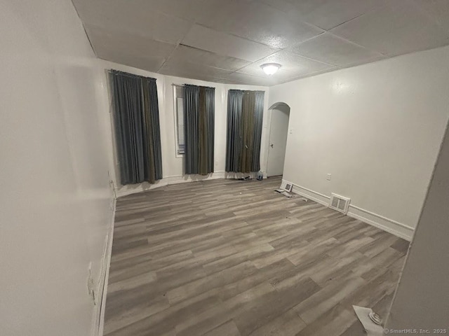 unfurnished room with hardwood / wood-style flooring and a paneled ceiling