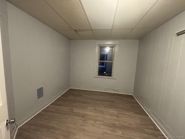 unfurnished room featuring a paneled ceiling and hardwood / wood-style flooring