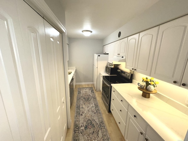 kitchen with white cabinets, appliances with stainless steel finishes, and light hardwood / wood-style floors