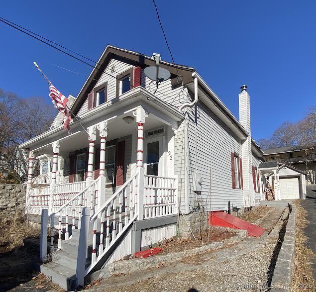 view of front facade featuring a garage, covered porch, and an outdoor structure