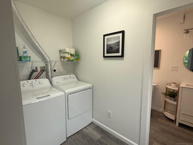 laundry area with washer and dryer, dark wood-type flooring, and baseboards