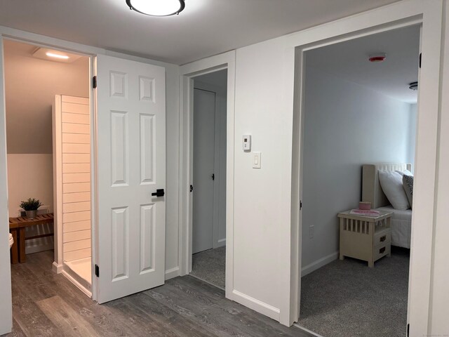 hall featuring dark wood-type flooring and baseboards