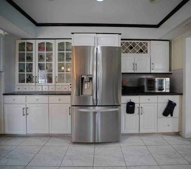 kitchen with stainless steel refrigerator with ice dispenser, white cabinetry, and ornamental molding