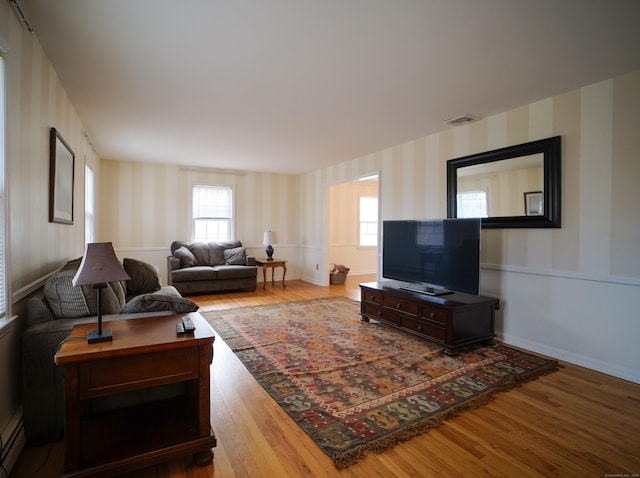 living room featuring a baseboard radiator and light hardwood / wood-style flooring