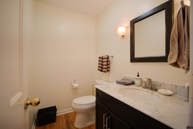 bathroom featuring toilet, vanity, and hardwood / wood-style flooring