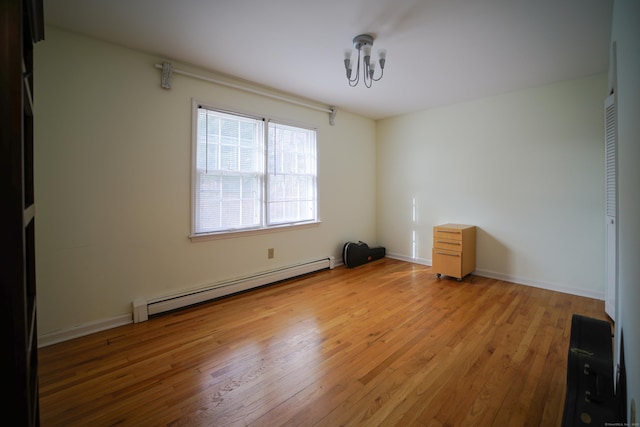 unfurnished room featuring a chandelier, light hardwood / wood-style floors, and baseboard heating