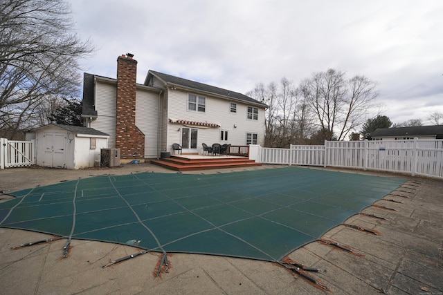 view of swimming pool featuring cooling unit, a storage unit, and a deck