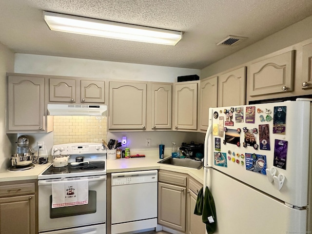 kitchen featuring sink, white appliances, and a textured ceiling