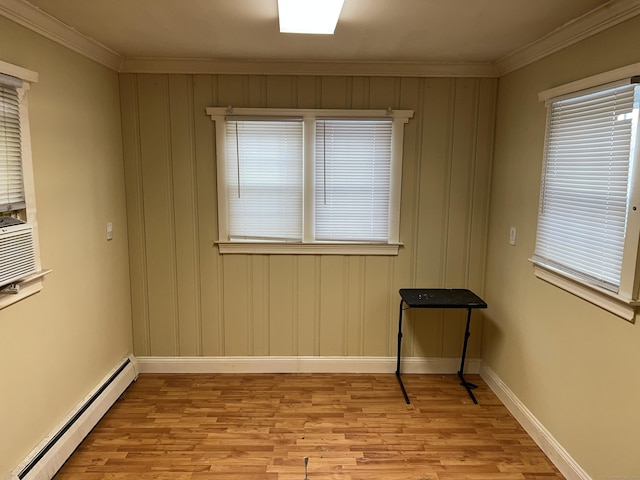 unfurnished room featuring ornamental molding, baseboard heating, and light hardwood / wood-style floors