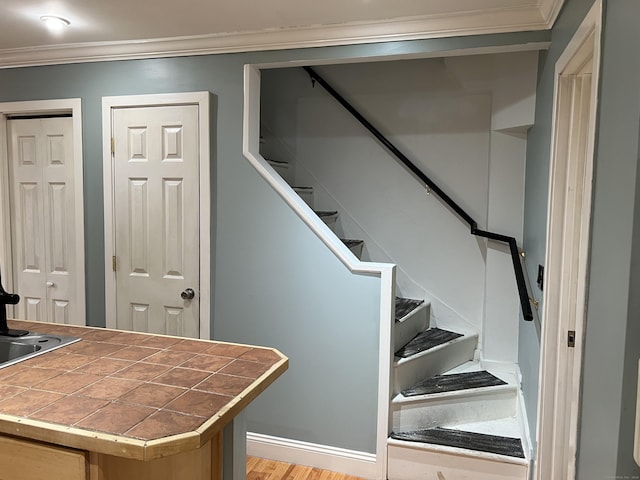 staircase with crown molding and hardwood / wood-style floors