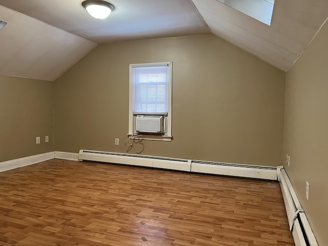 bonus room with cooling unit, a baseboard radiator, and vaulted ceiling with skylight