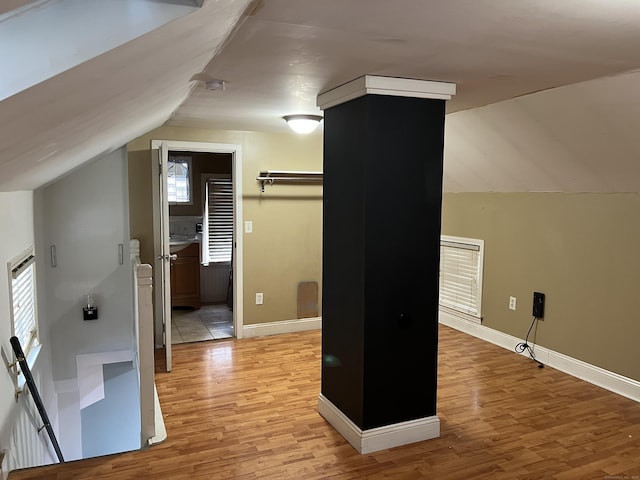 bonus room with lofted ceiling and light hardwood / wood-style floors