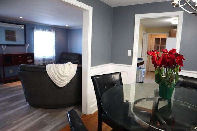 dining space with hardwood / wood-style floors and a notable chandelier