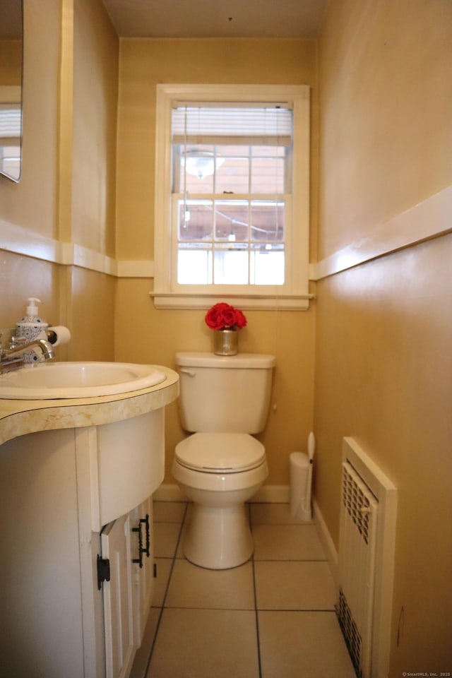 bathroom featuring toilet, radiator heating unit, and tile patterned flooring