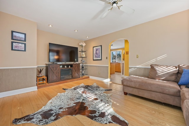 6264 Main St, Trumbull, CT 06611 - living area featuring wainscoting, hardwood / wood-style floors, arched walkways, ceiling fan, and baseboards