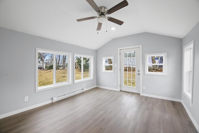 empty room featuring ceiling fan, light hardwood / wood-style flooring, lofted ceiling, and a baseboard heating unit