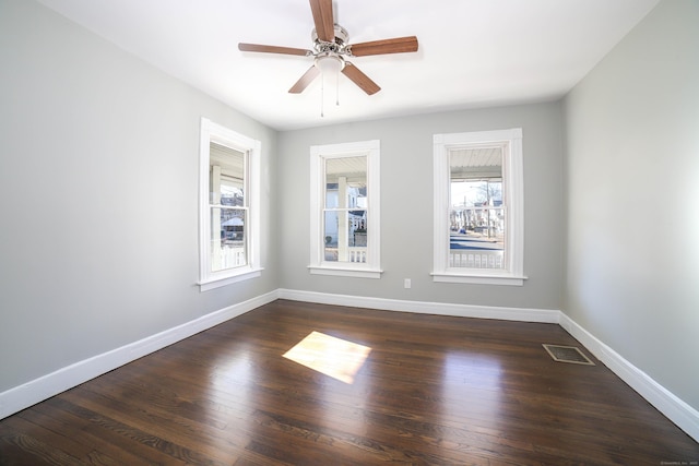 empty room with ceiling fan and dark hardwood / wood-style floors