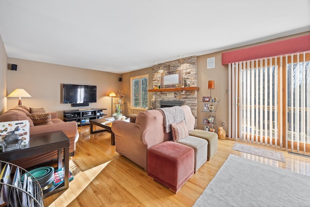 living room featuring light hardwood / wood-style flooring and a stone fireplace